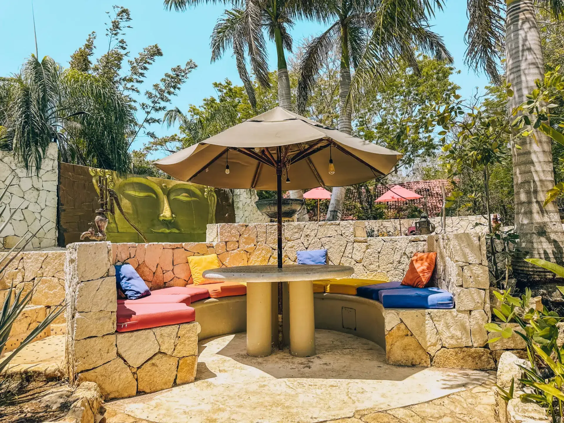 Hay una mesa y una sombrilla en el medio del jardín.