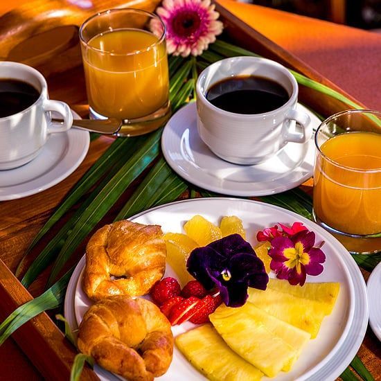 Una bandeja de madera con platos de comida y bebidas encima.
