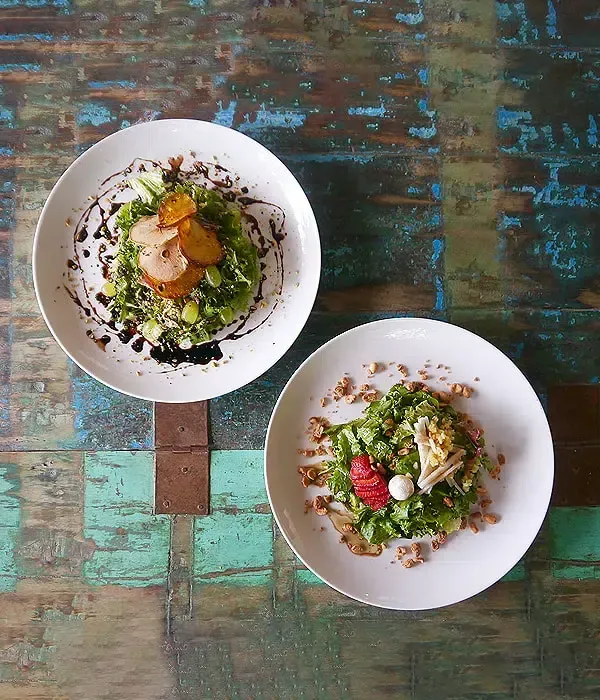 Dos platos de comida están sobre una mesa de madera.