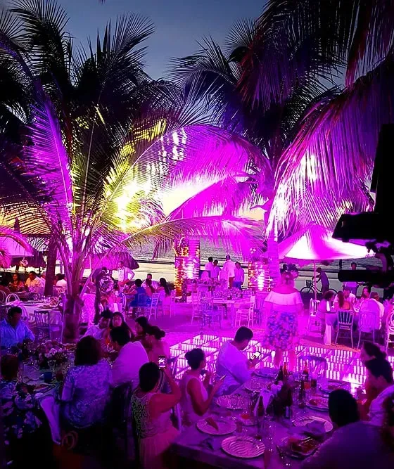 A hand holding a glass in a beach