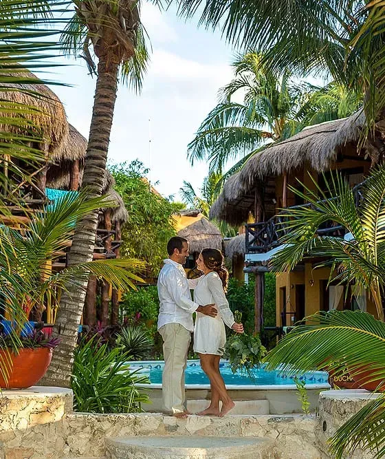 Hay tres tacos en una bandeja de pizarra sobre una mesa al lado de un plato de camarones.