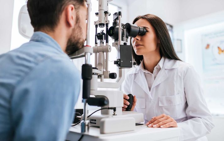 A man is getting his eyes examined by an ophthalmologist.