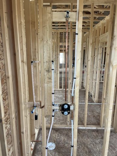 A house is being built with wooden beams and pipes.