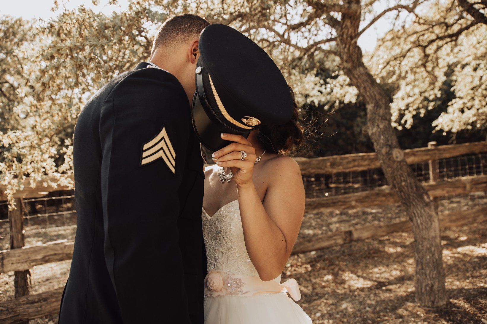 Shy Bride and Groom Kiss Behind Hat - Outdoor Wedding Photo