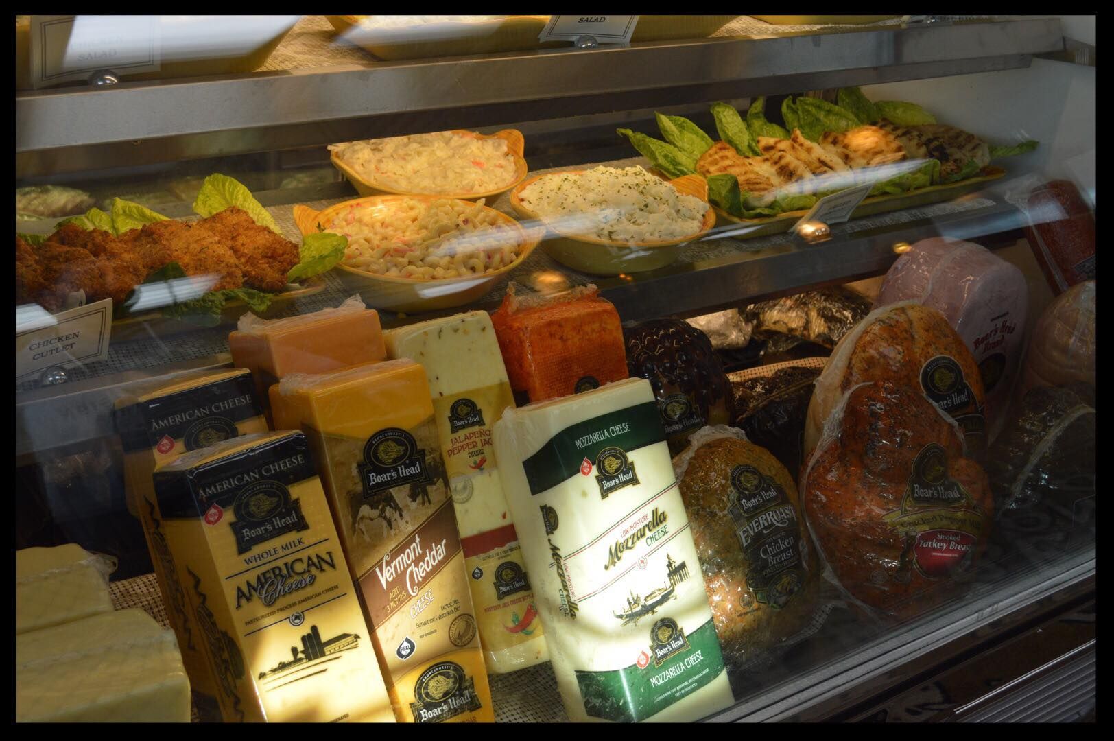 A display case filled with a variety of cheeses and meats.