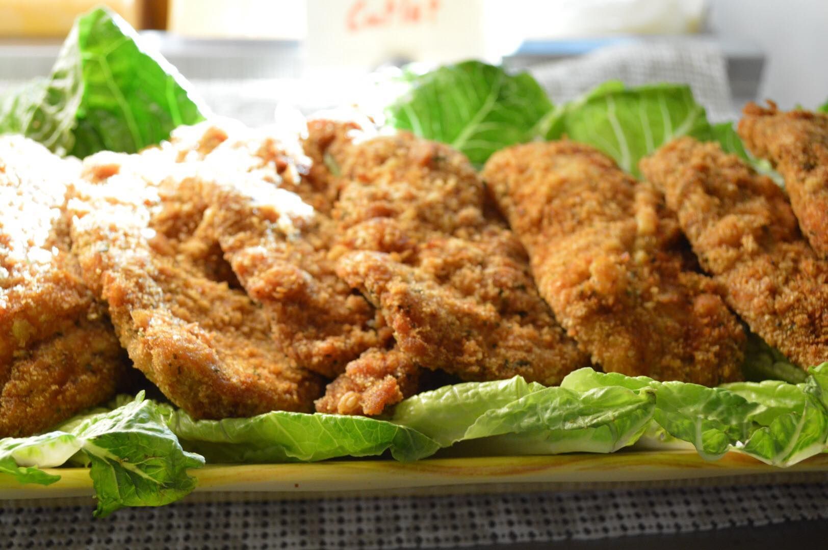 A white plate topped with a variety of sandwiches and fruit.