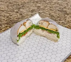 A sandwich is cut in half on a white plate on a table.