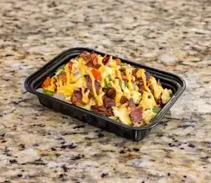 A black plastic container filled with food is sitting on a granite counter.