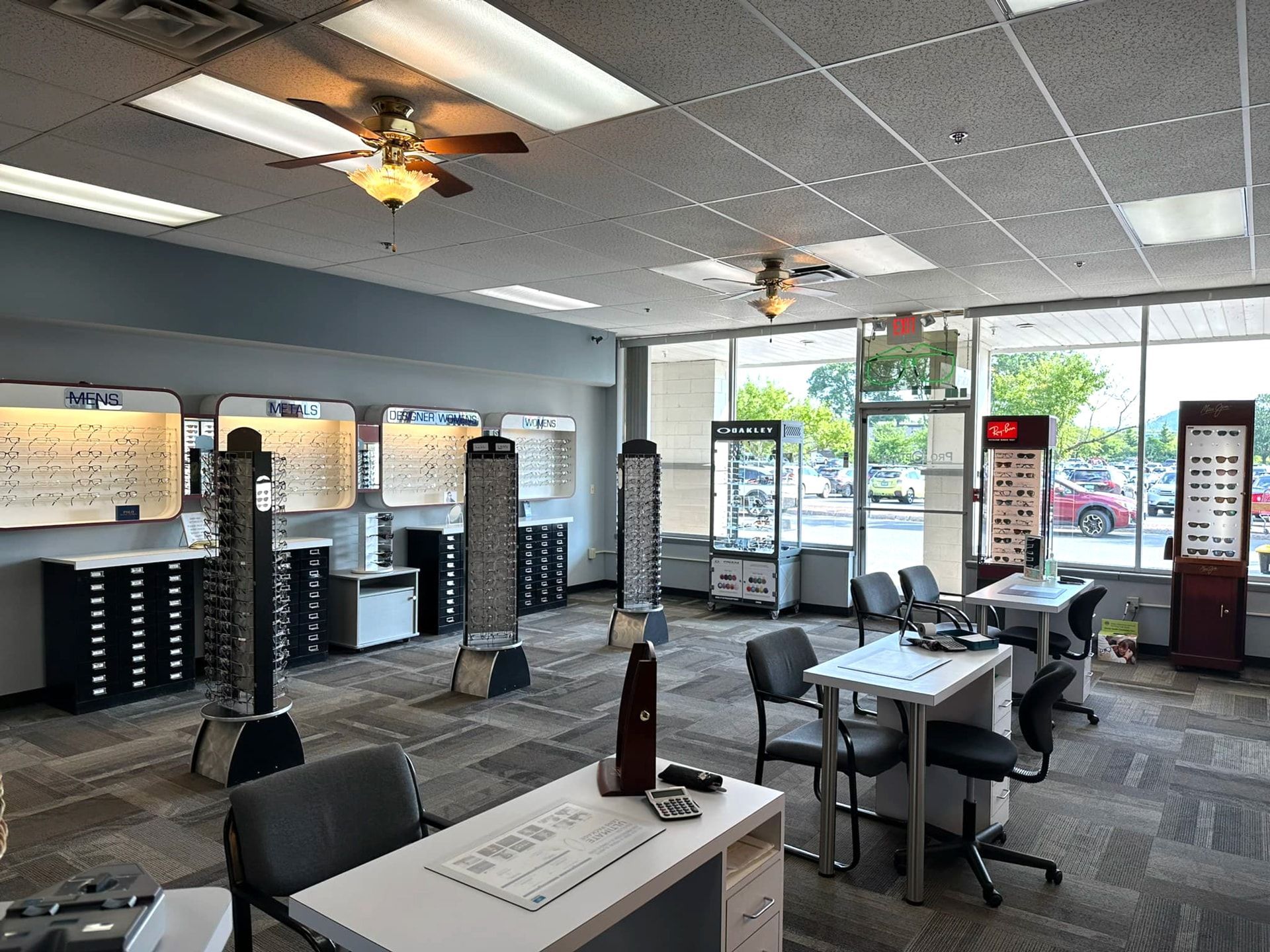 A large room with a lot of windows and a ceiling fan in an optical shop.