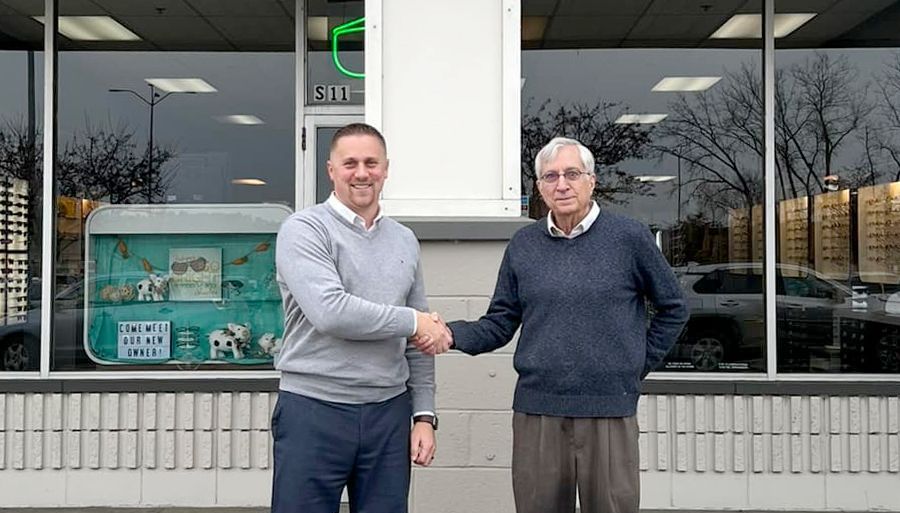 Dan Haselton and new owner Jeff LaClair shaking hands in front of Pro Optical in West Lebanon NH