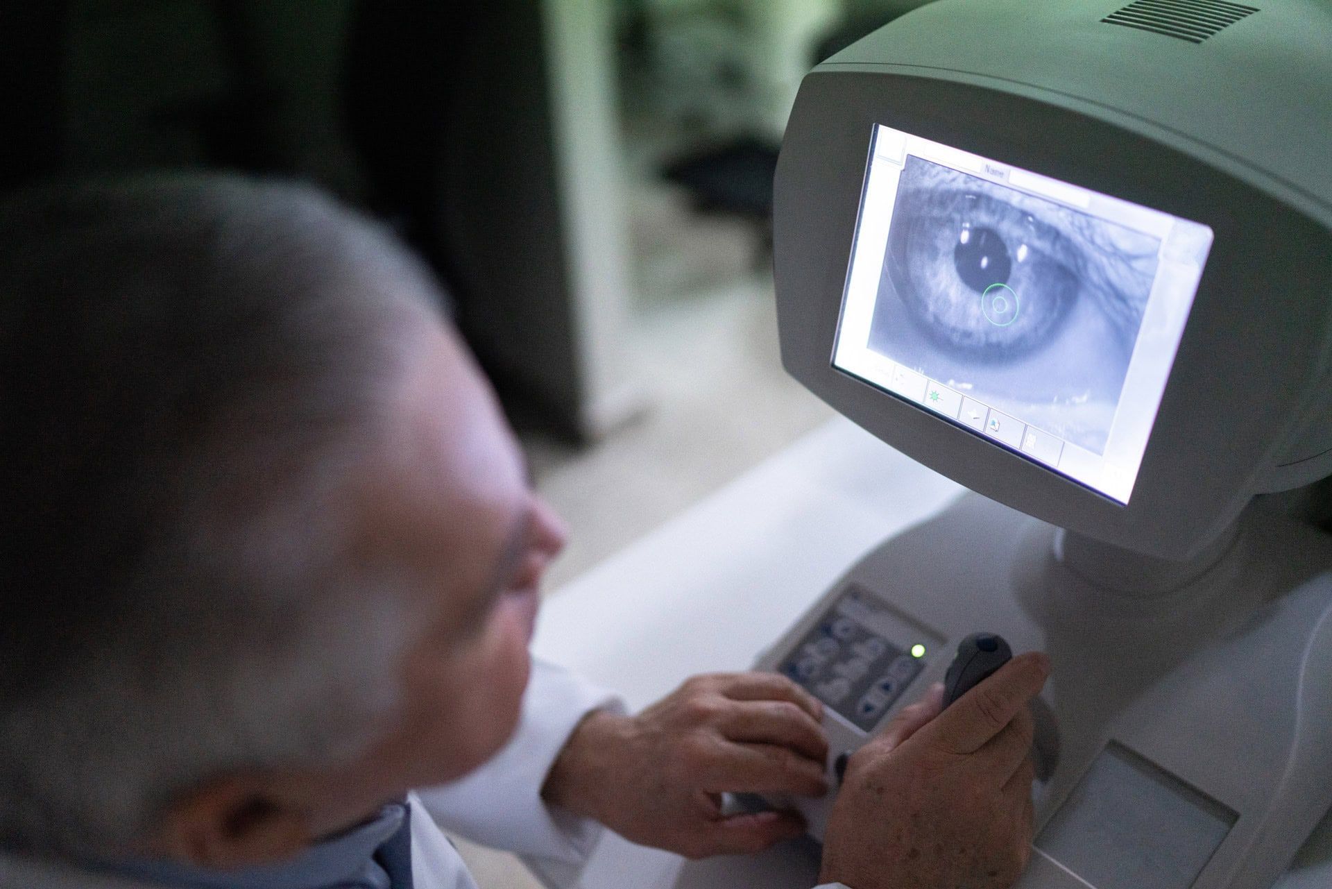 A man is looking at an eye on a monitor