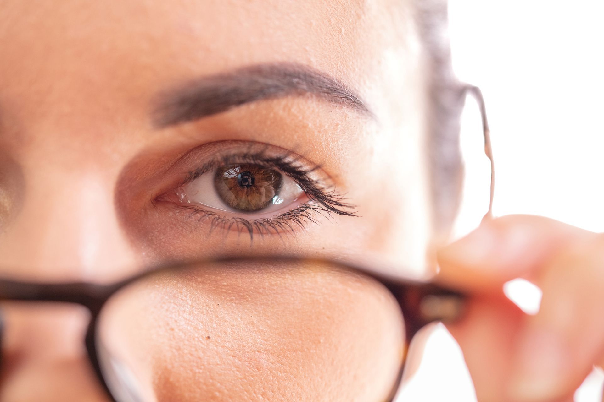 A close up of a woman 's eye wearing glasses.