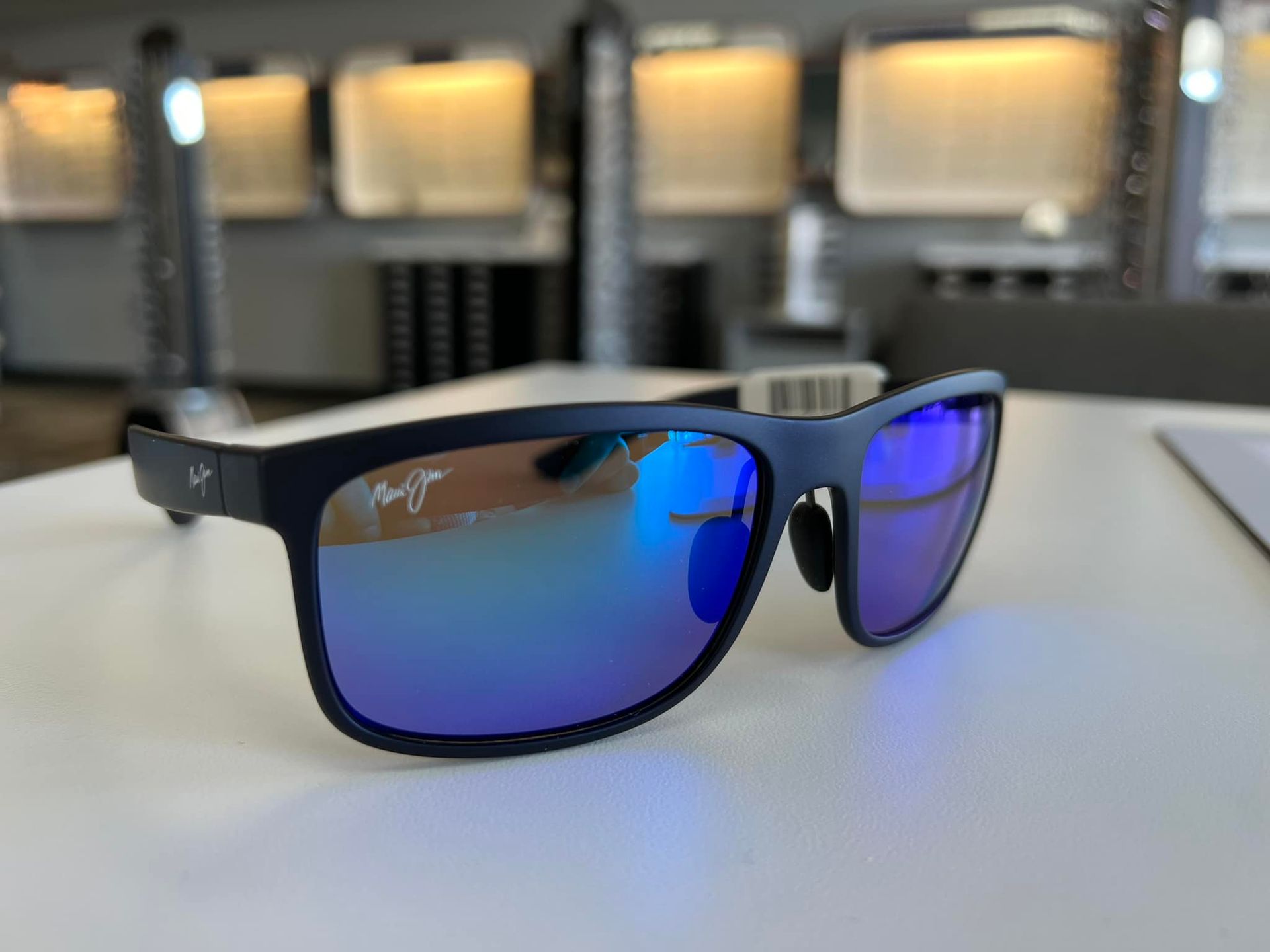 a pair of blue Maui Jim sunglasses on a table  at Pro Optical in West Lebanon, NH