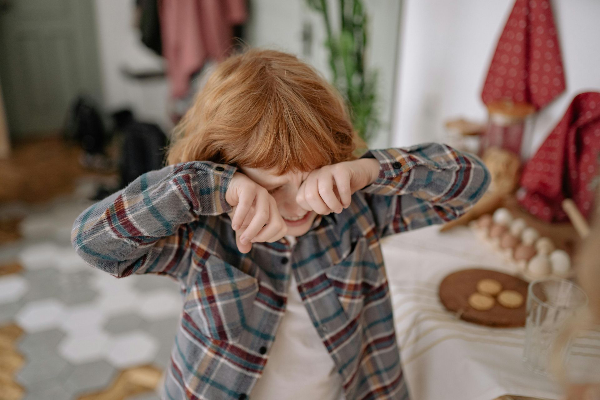 A child showing signs of eye allergies, with watery eyes and a slight frown.