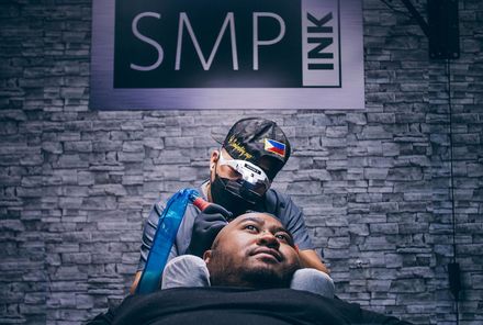 An SMP INK CDA Student Practitioner drawing the reference line on the scalp of  an SMP client in a class setting.