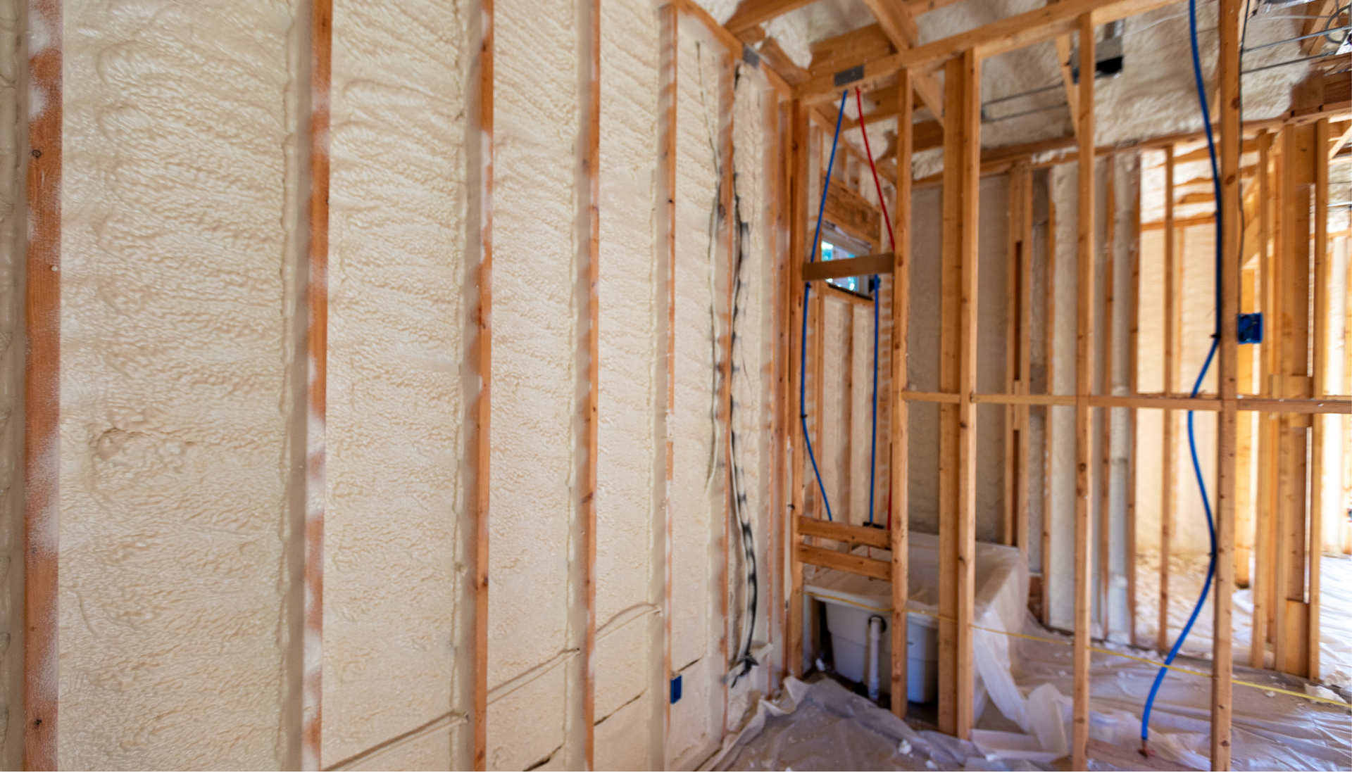 A room in a house under construction with foam insulation on the walls.