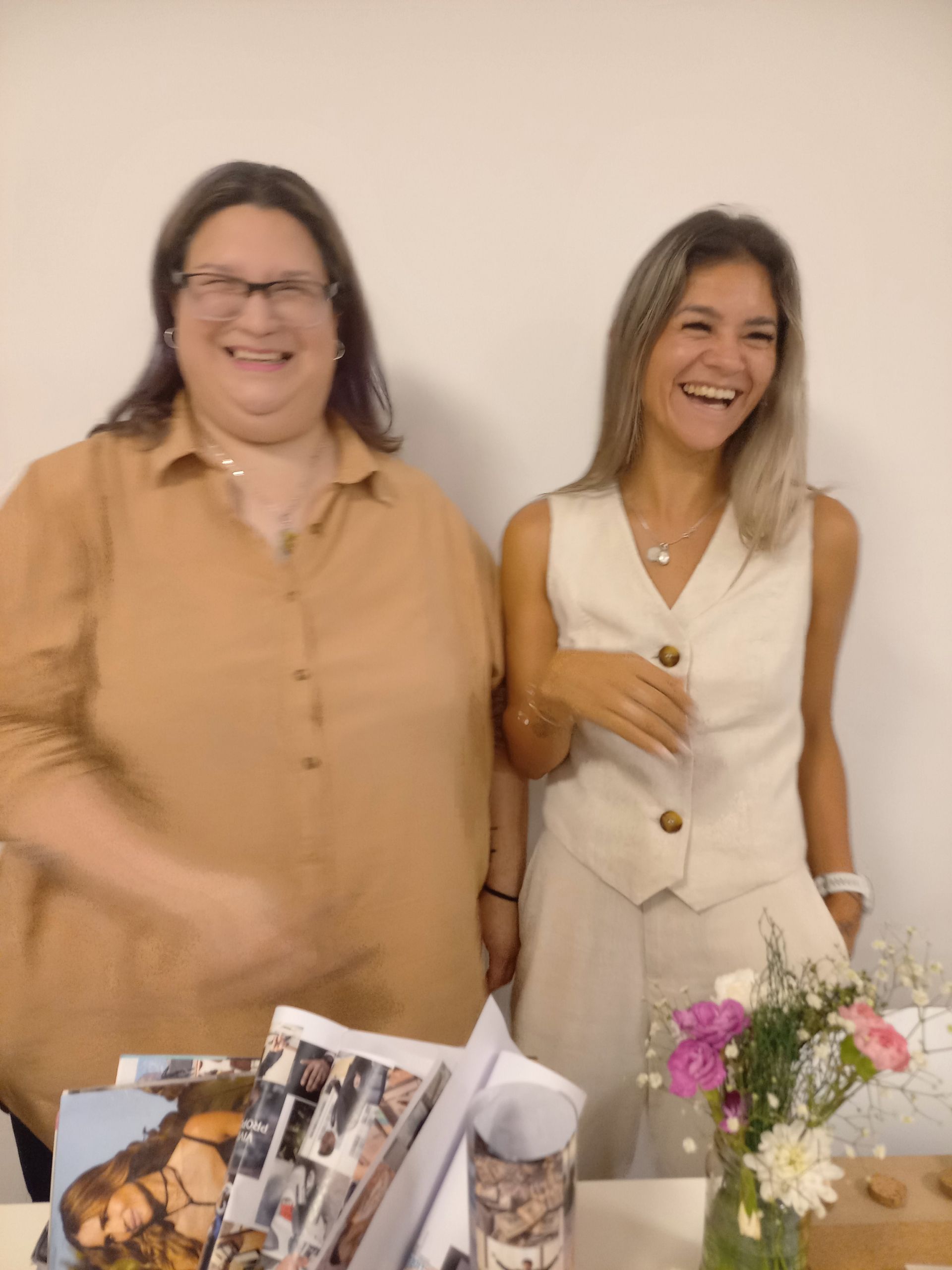 Dos mujeres están paradas una al lado de la otra y sonriendo