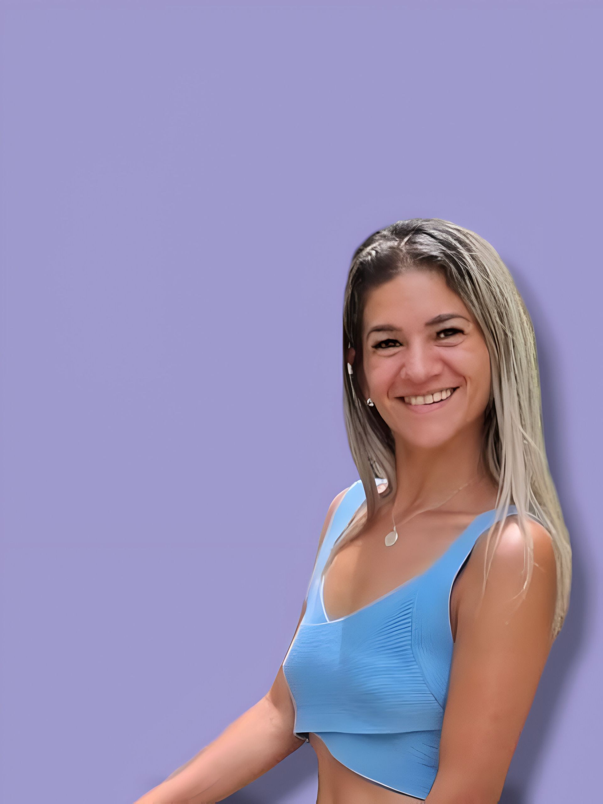 Una mujer con un top azul sonríe sobre un fondo morado.