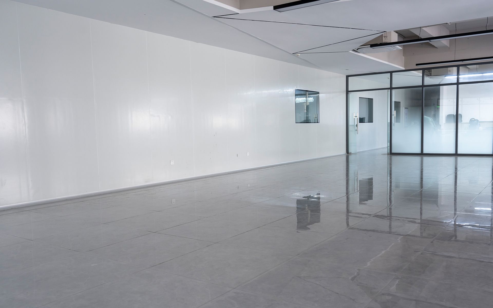 A large empty room with white walls and a shiny floor.