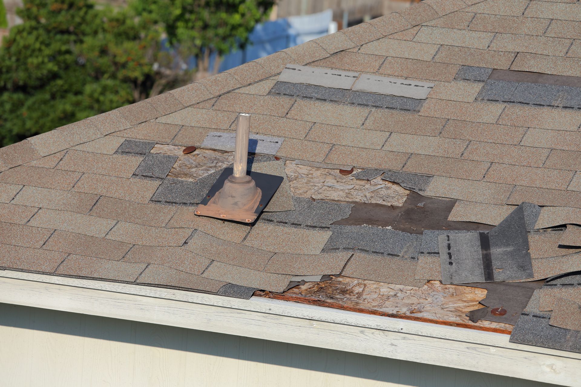 A roof with a hole in it and shingles missing.