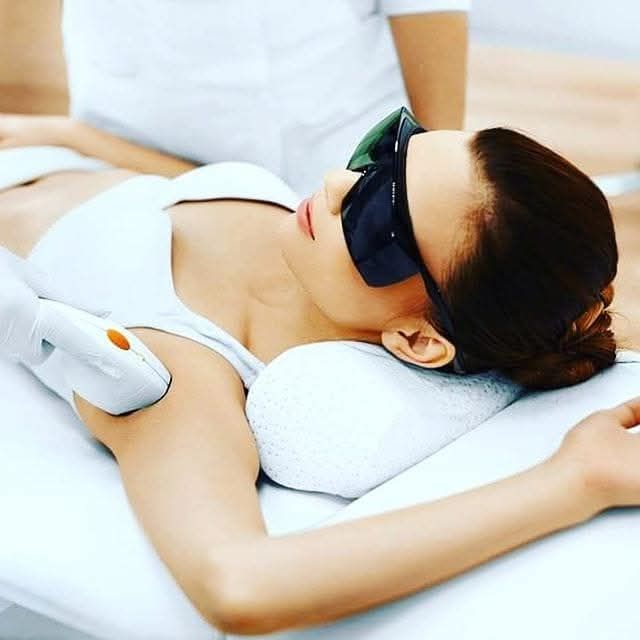 Une femme reçoit un soin du visage dans un salon de beauté.