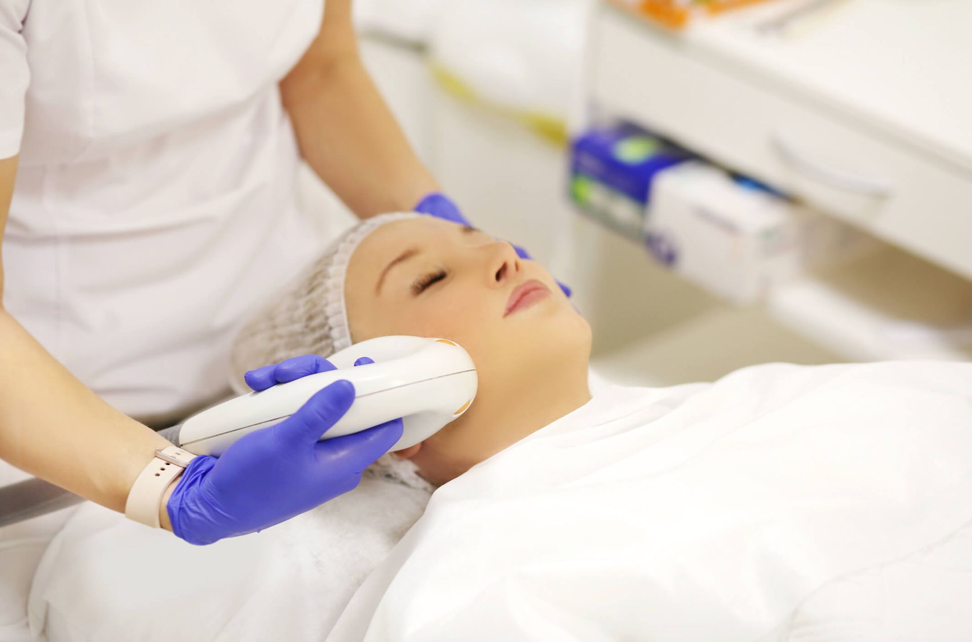 Une femme reçoit un soin du visage dans un salon de beauté.