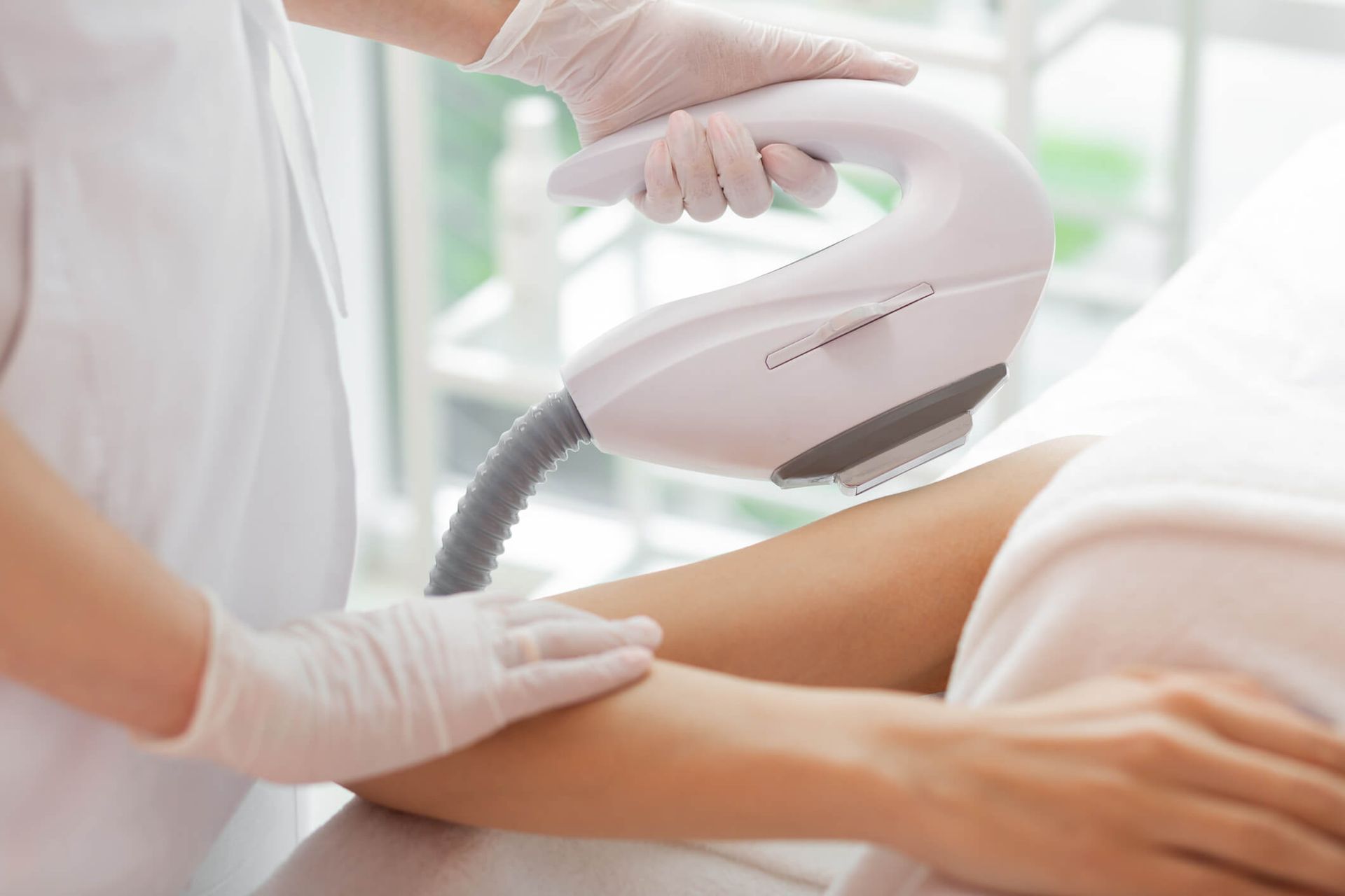 Une femme subit un traitement d'épilation au laser sur son bras.