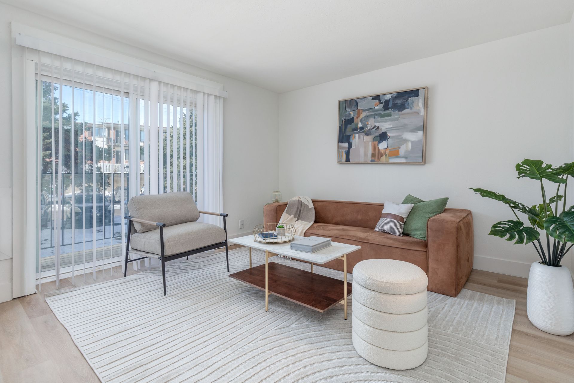 A living room with a couch , chair , coffee table and sliding glass doors.