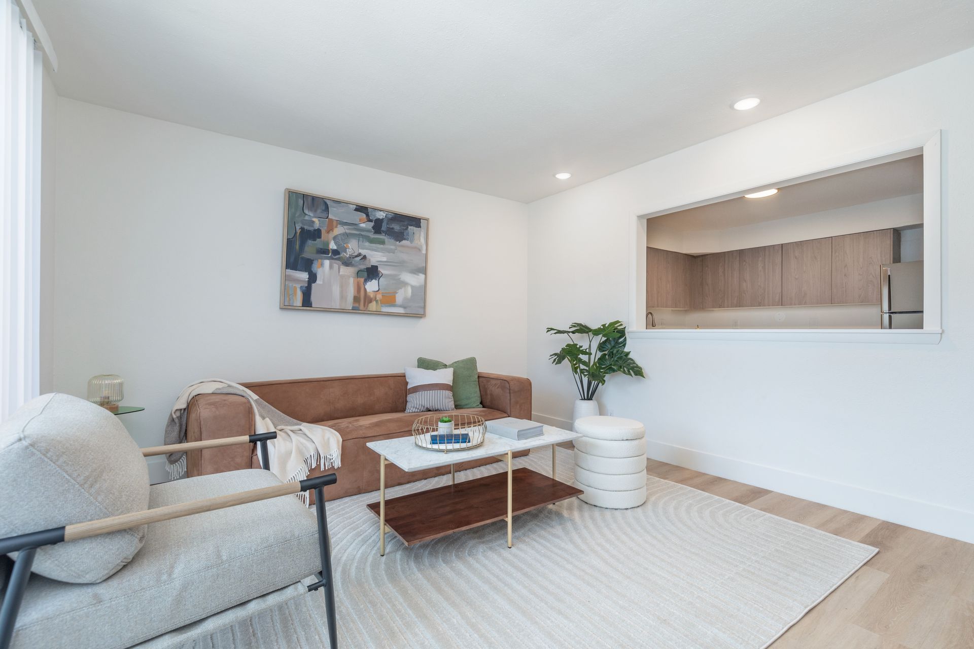 A living room with a couch , chair , coffee table and rug.