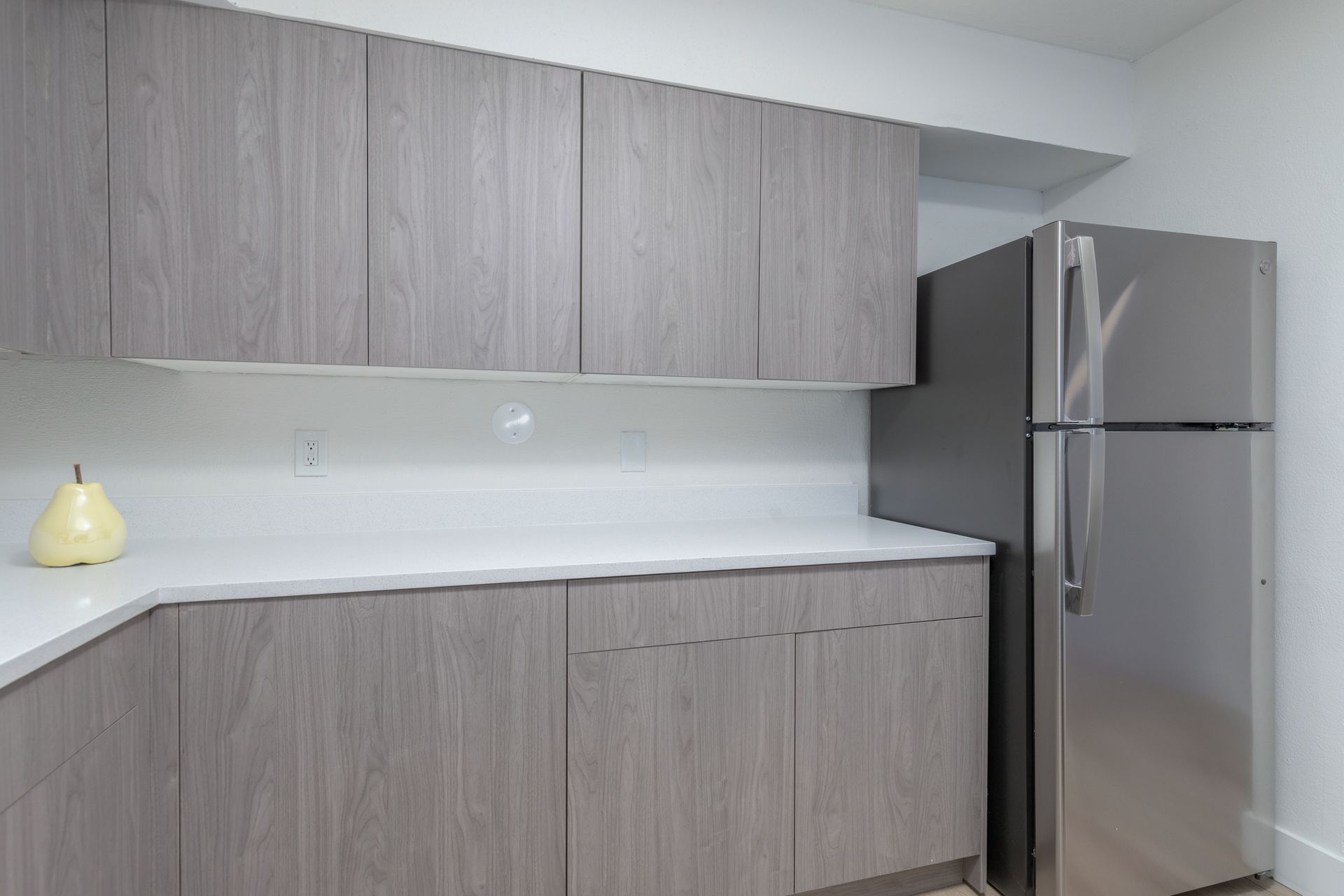 A kitchen with stainless steel appliances and wooden cabinets.