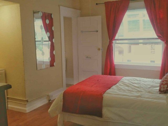 619 Bedroom with red bedspread and red curtains