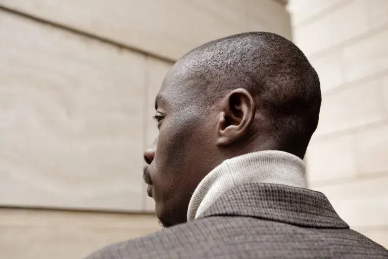 The back of a man wearing a suit and a turtleneck.