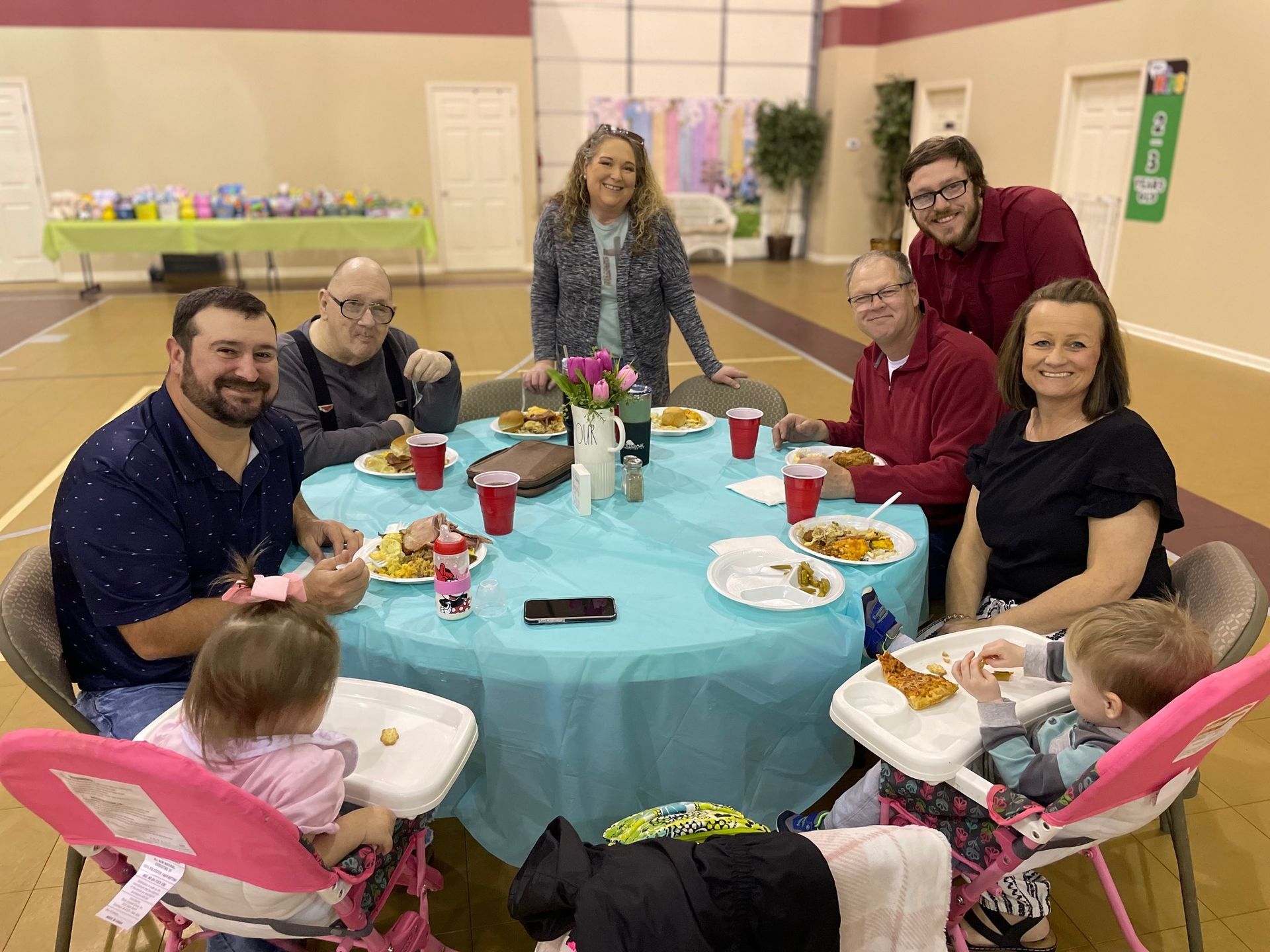 A group of people are sitting around a table eating food.