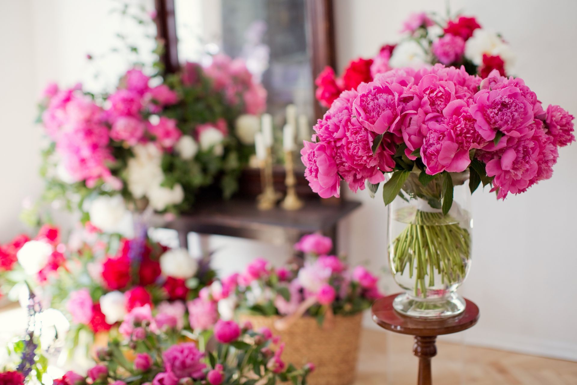 A vase filled with pink flowers is sitting on a table. A vase filled with pink flowers is sitting on a table.