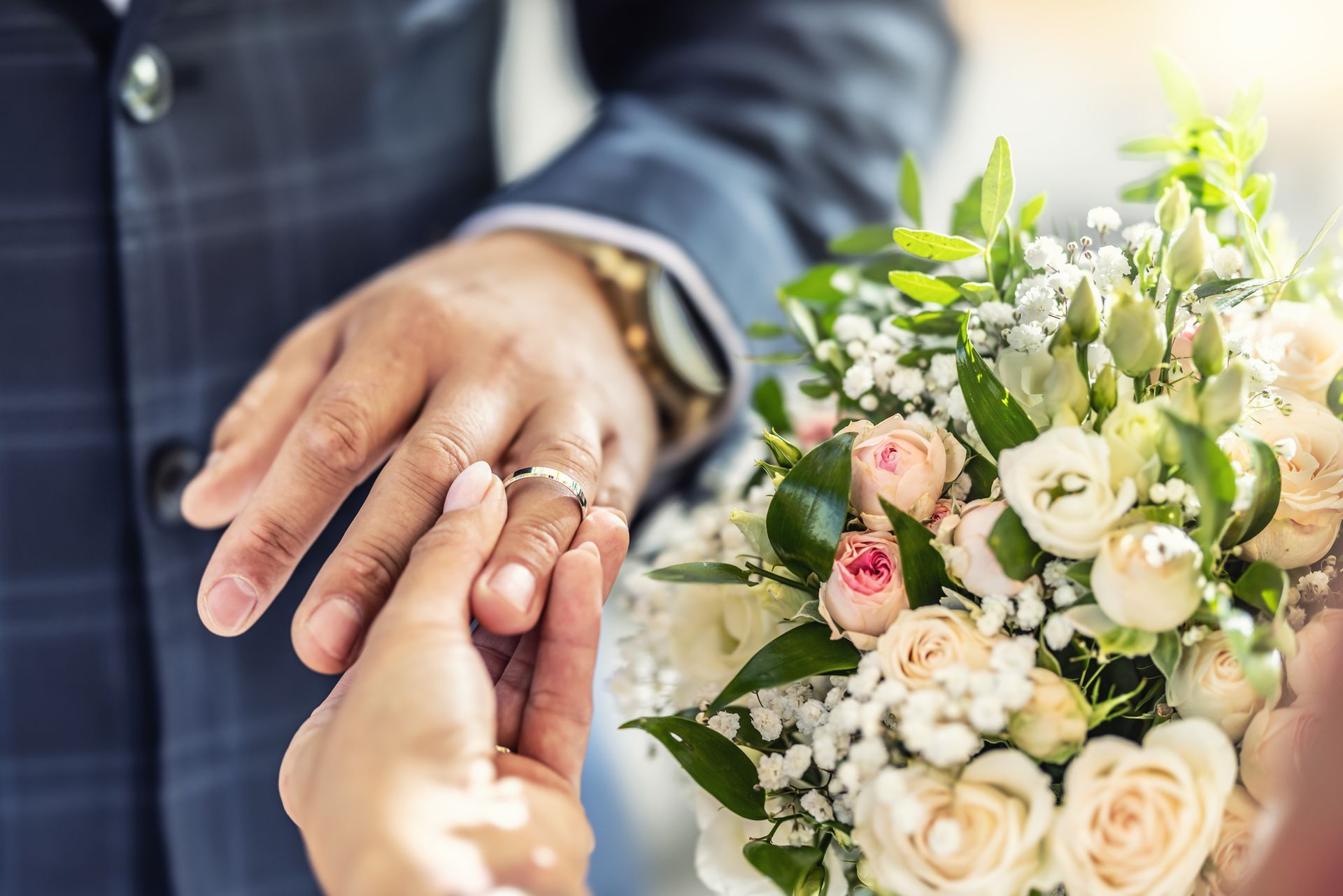 A man is putting a wedding ring on a woman 's finger. A man is putting a wedding ring on a woman 's finger.