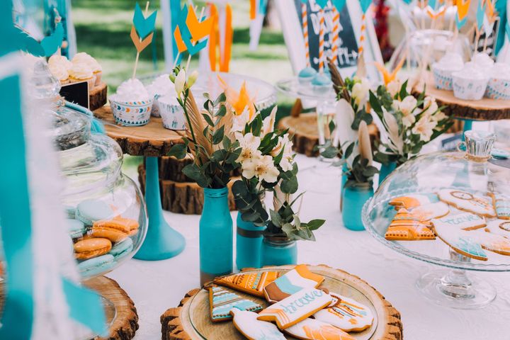 A table decorated with flowers and cookies for a birthday party.