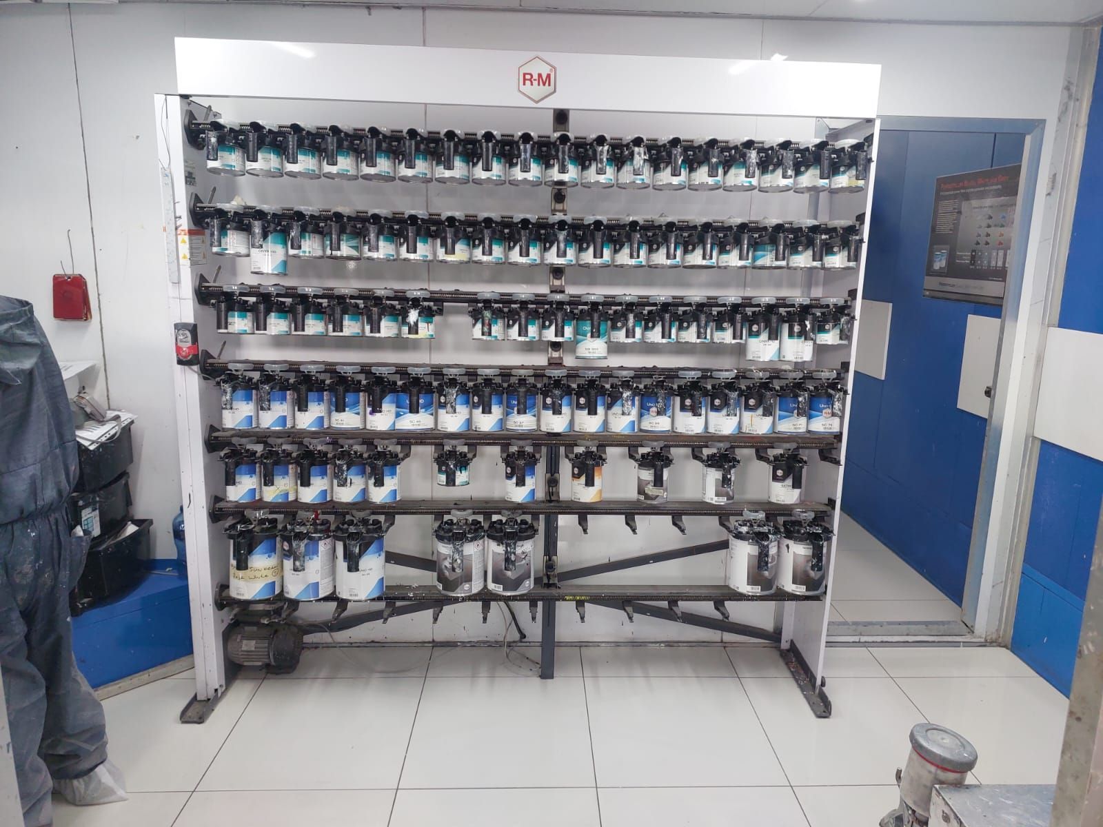 A shelf filled with lots of paint bottles in a room.
