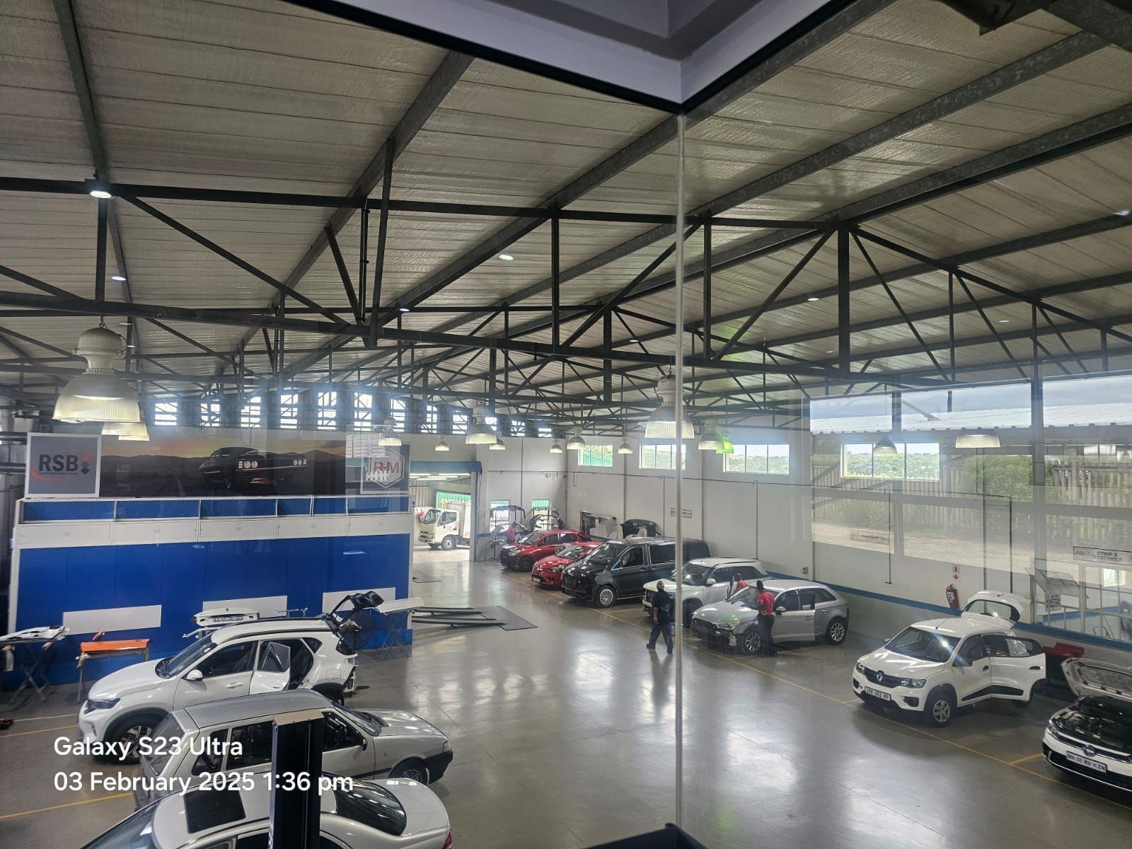 A lot of cars are parked in a large garage.