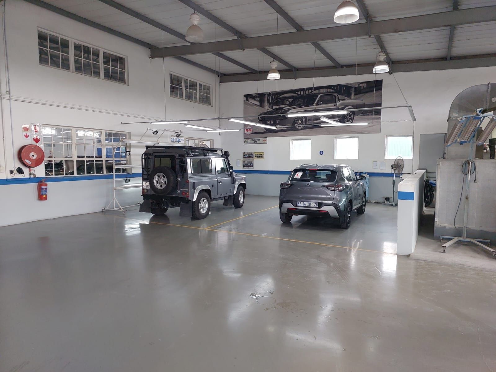 A row of old cars are parked in a garage