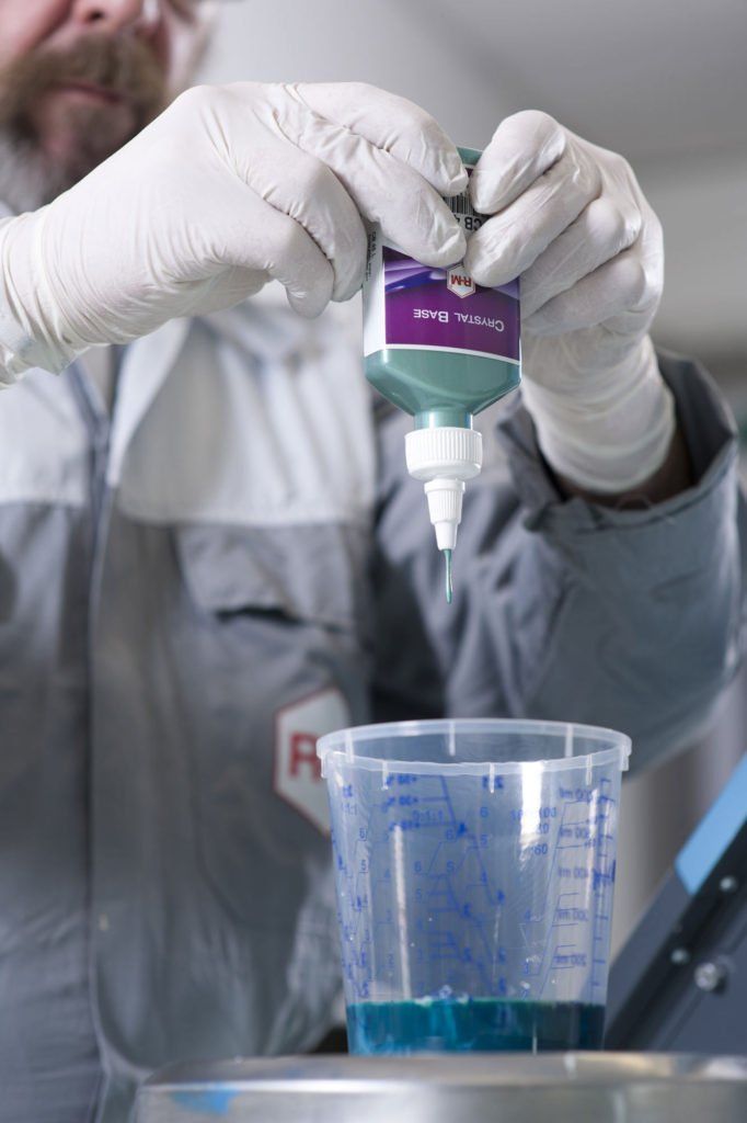 A man is pouring liquid into a measuring cup.