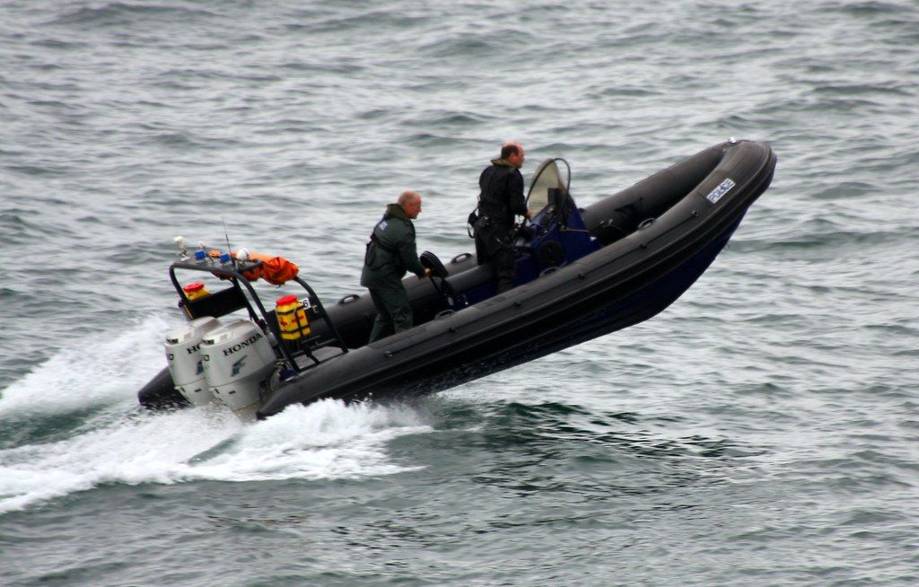 Two men are riding a boat in the ocean.