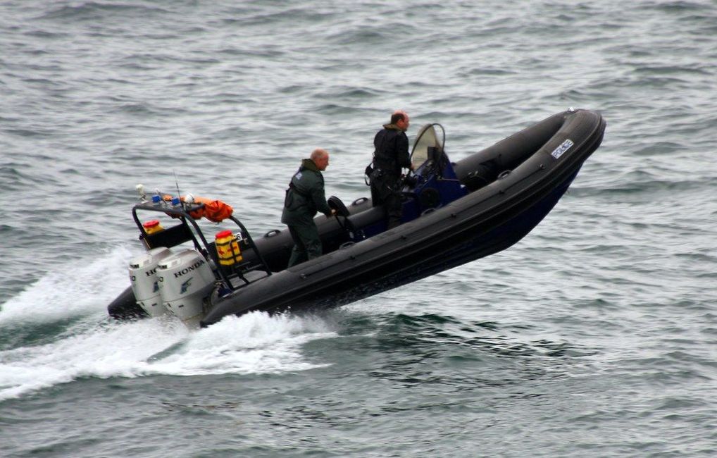 Two men are riding a boat in the ocean.