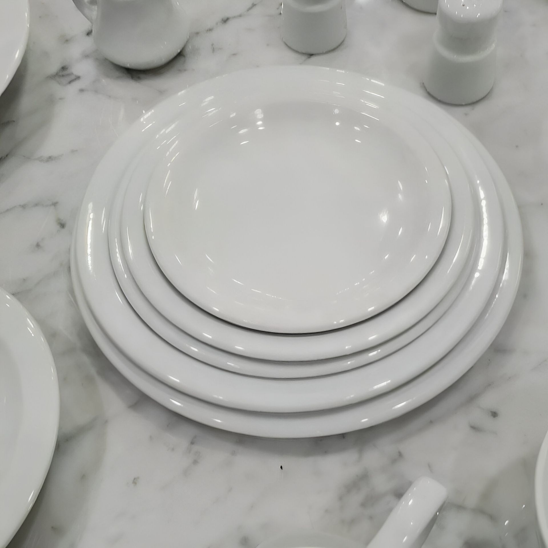 Platos blancos apilados uno encima del otro sobre una mesa