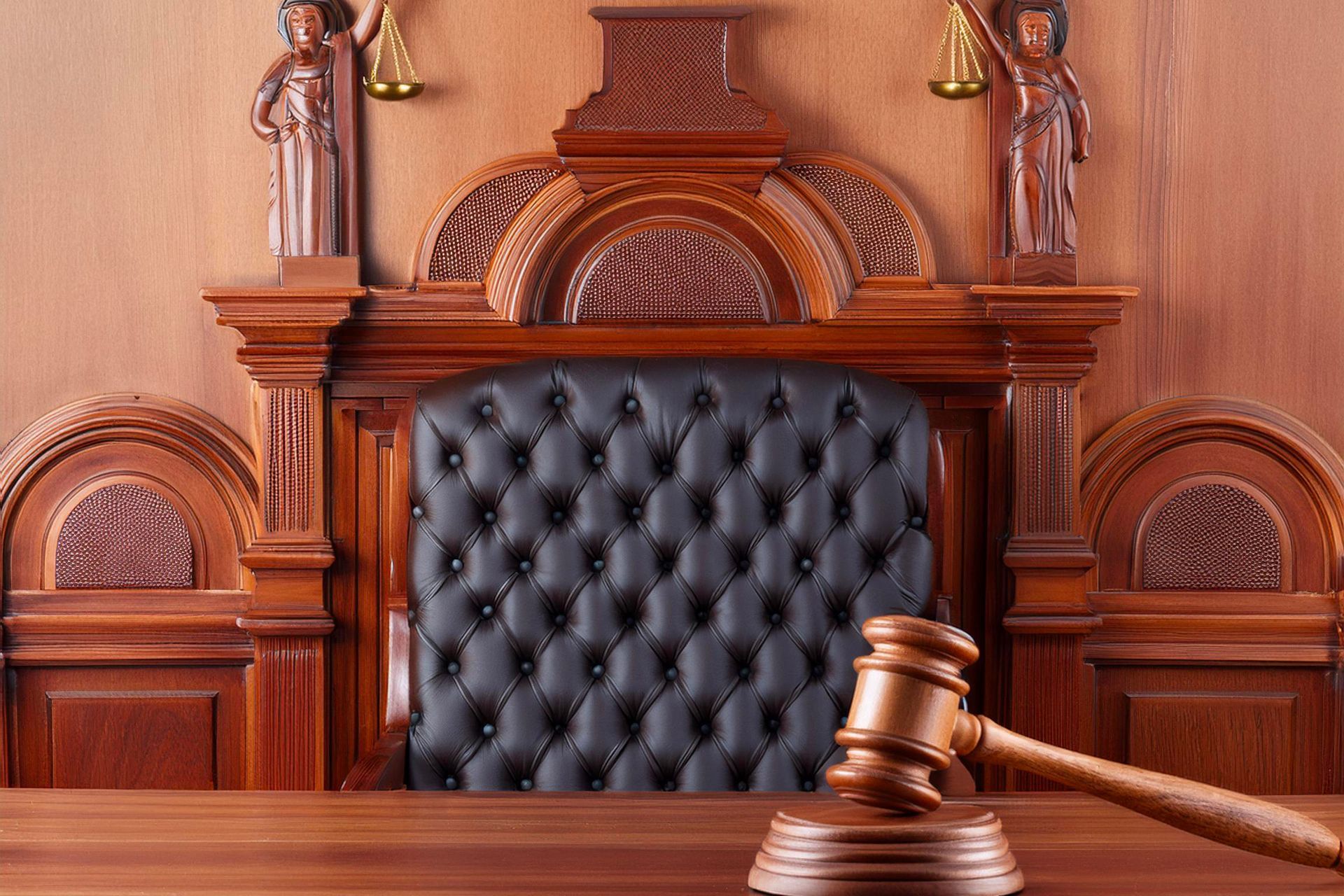 A wooden judge 's gavel is sitting on a wooden table in a courtroom.