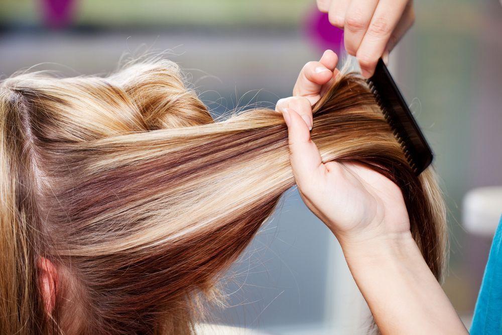 A Woman is Getting Her Hair Done by a Hairdresser — Energy Hair Co in Noosa Heads, QLD