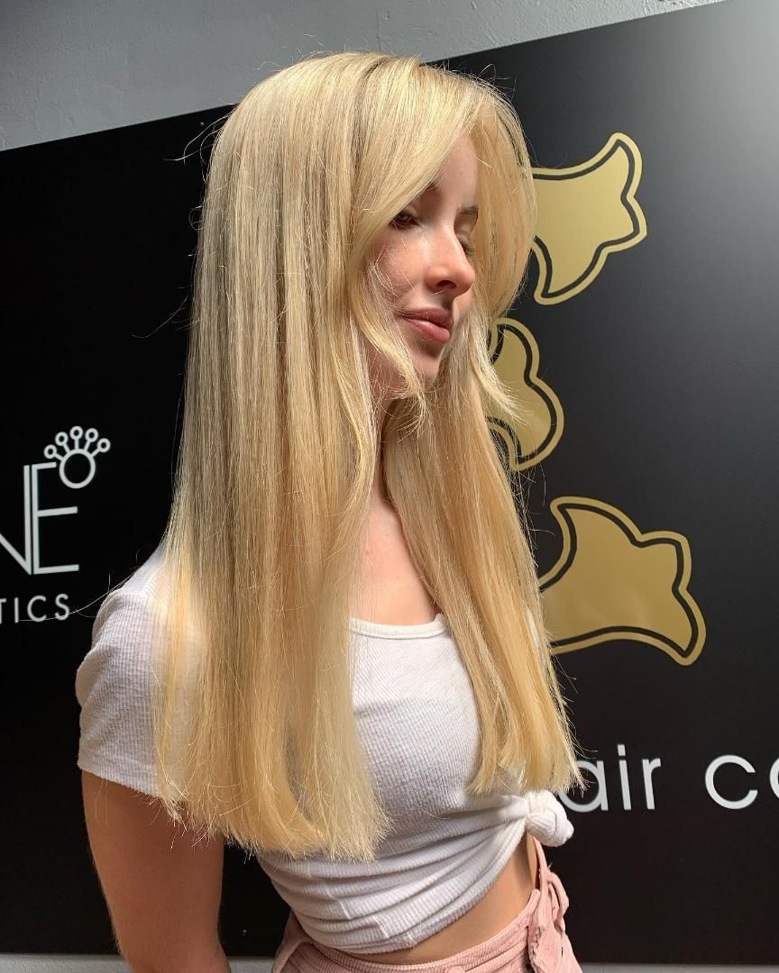 A Woman With Long Blonde Hair is Wearing a White Shirt — Energy Hair Co in Noosa Heads, QLD