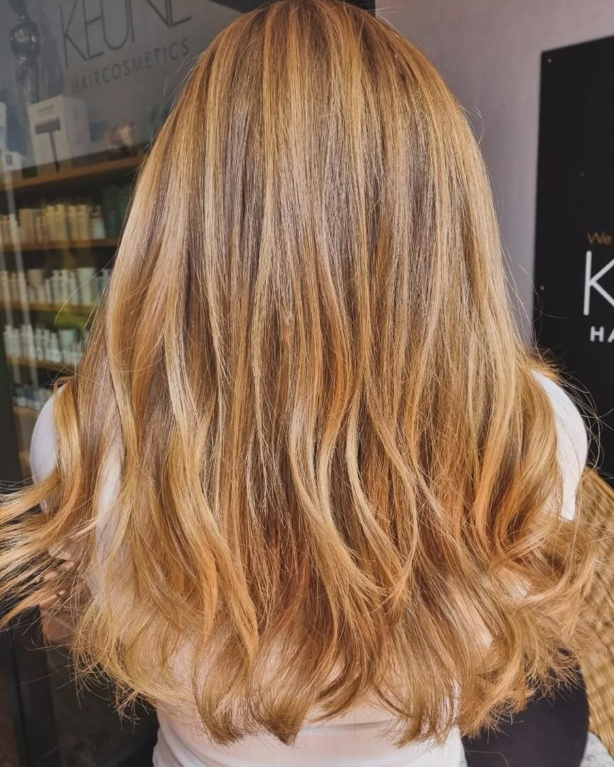 A Woman With Long Blonde Hair is Wearing a White Shirt — Energy Hair Co in Noosa Heads, QLD