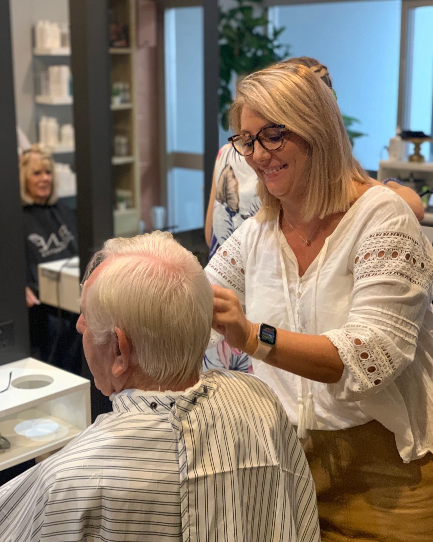 A Woman With Curly Hair is Wearing a White Dress and Smiling — Energy Hair Co in Sunshine Coast, QLD