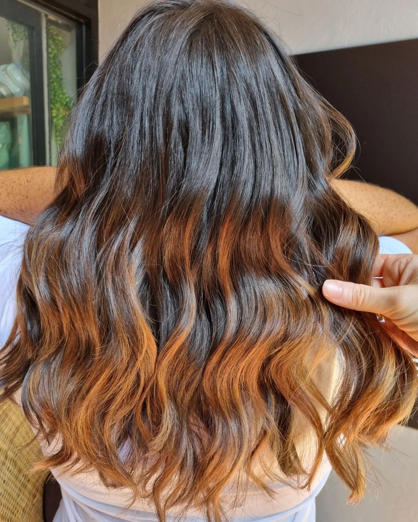 A Woman in a Black Dress With a Plunging Neckline is Looking at the Camera — Energy Hair Co in Noosa Heads, QLD