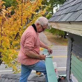 Dan is working on the roof of a house
